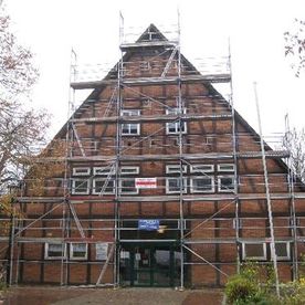 Sanieren von Unterschlägen, Stirnbrettern und Deckleisten an einem Fachwerkgiebel.