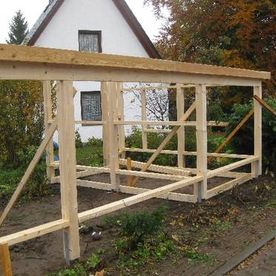 Nächster Schritt: Konstruktionsvollhölzer werden für das Carport mit Geräteschuppen entsprechend auf dem vorgenannten Fundament angebracht.