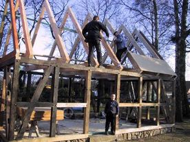 Sanieren eines alten Fachwerkgebäudes nach einem Brand. Hier wird altes Eichenkant- holz an den zerstörten Bereichen des Fachwerks eingesetzt und der Dachstuhl komplett neu aufgebaut.