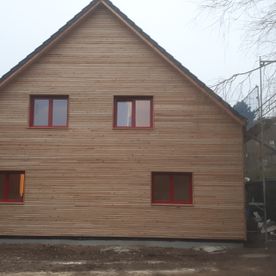 Hinterlüftete Vorhangfassade mit UV-Beständiger Fassadenbahn, auf die Konstruktion kam eine Rombusschalung aus sibirischer Lärche.